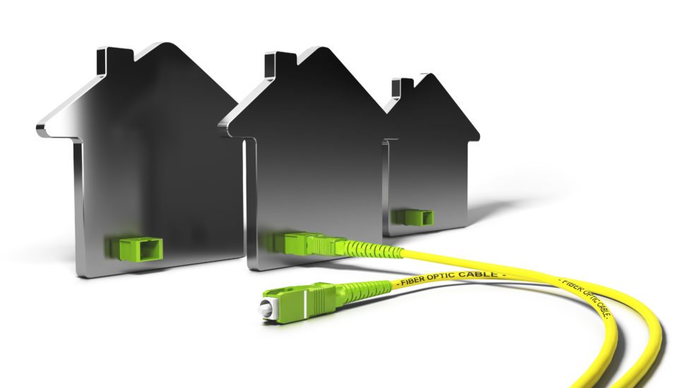 Fiber-optic cable in front of model houses — symbol of FTTH connectivity