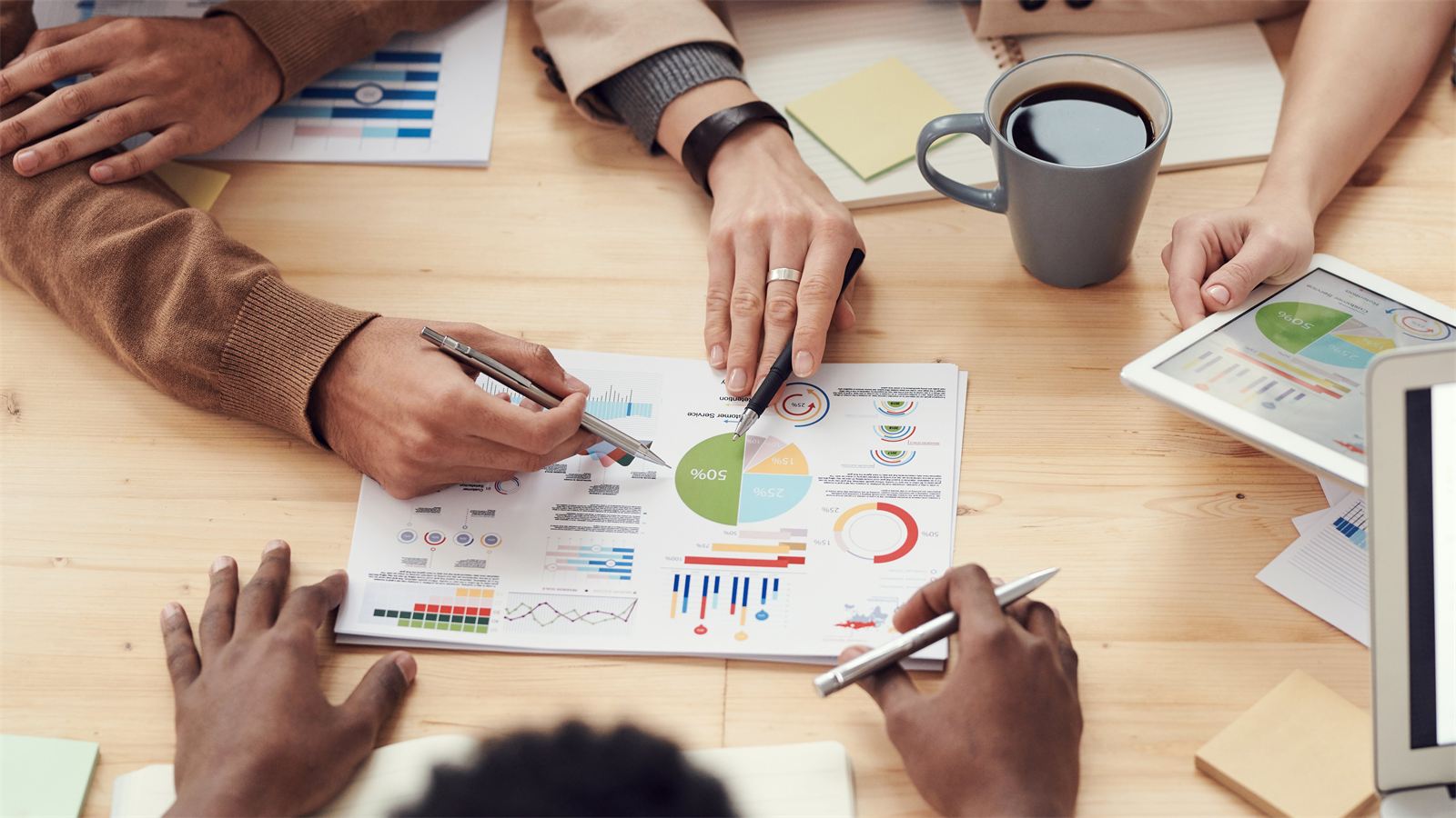 Consulting team jointly analyzing cost reports and charts
